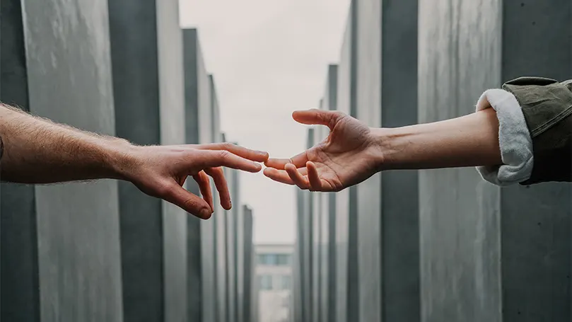 An image of two hands reaching out to each other for help