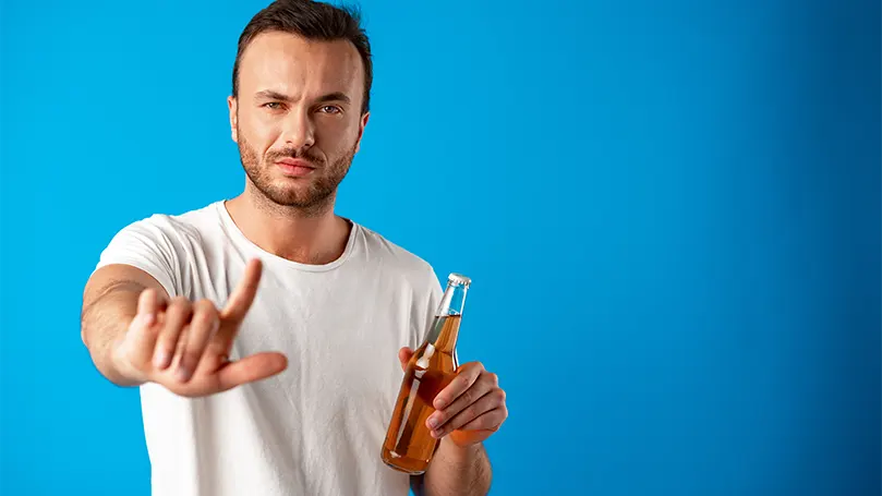 An image of a man refusing to drink alcohol