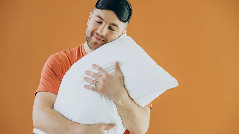 An image of a man hugging a pillow