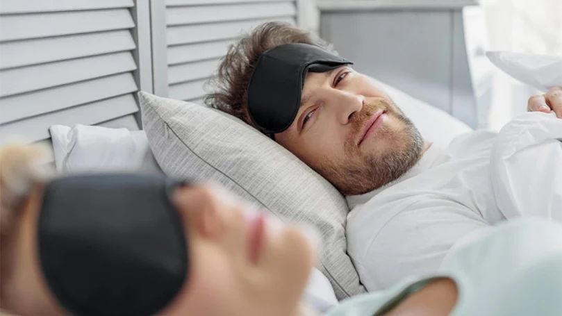 a couple in a bed with eye masks