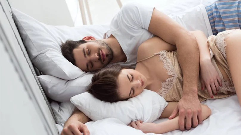 an image of a couple sleeping comfy in a bed