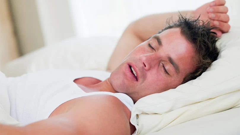 an image of a man sleeping on his back and snoring