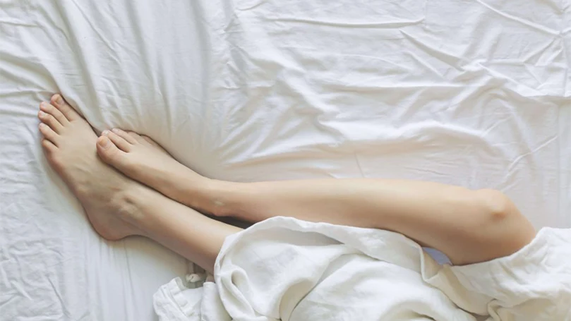 a woman laying down on beddings in a bed