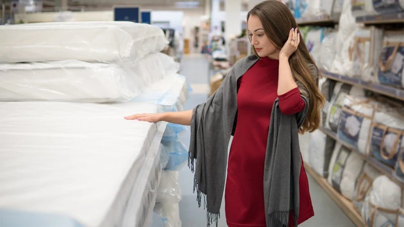 an image of a woman shopping for a new mattress