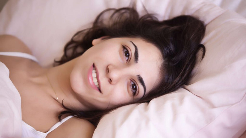 woman laying on a pillow, smiling