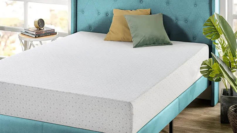 An image of a memory foam mattress on a blue bed.