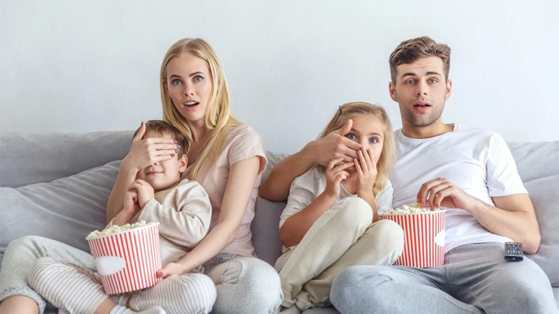 an image of parents are watching scary movie with kids