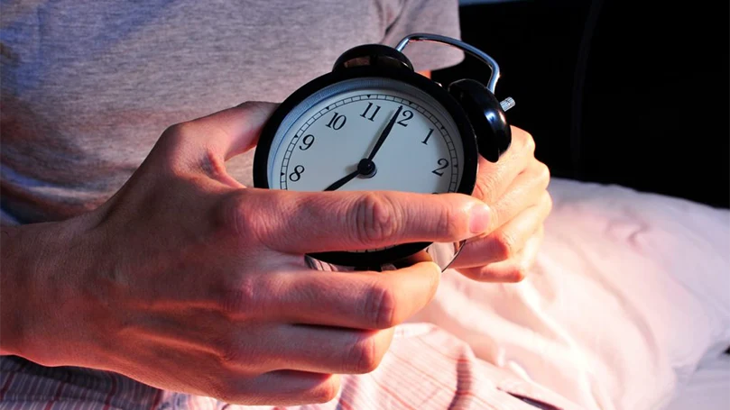 an image of a man setting an alarm clock