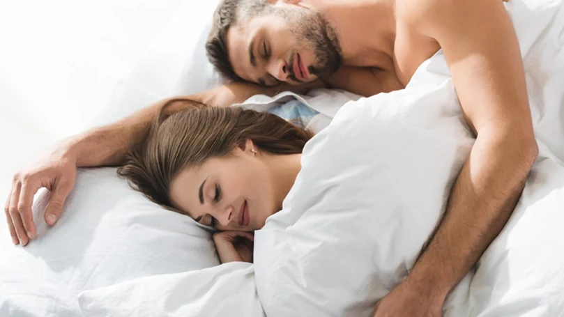 an image of a couple sleeping in a bed comfortably