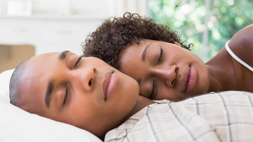 an image of a couple sleeps comfortably in a bed