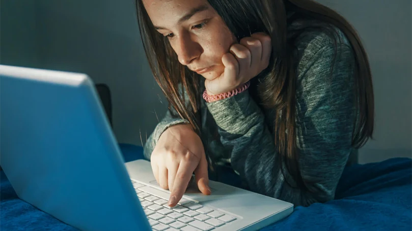 an image of a girl working on a computer at night