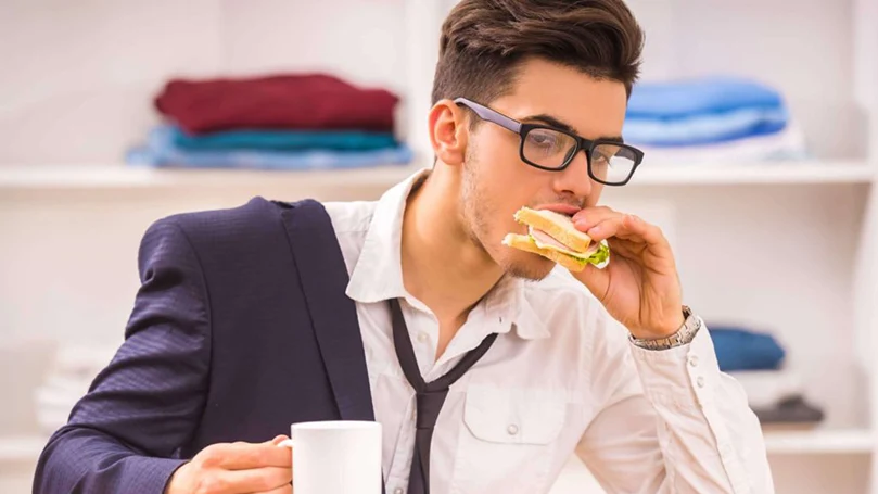 an image of a man eating fast to get to the work on time