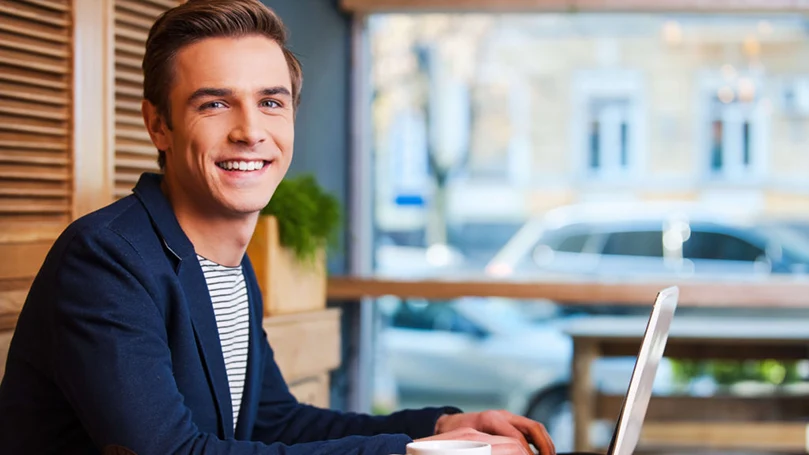 a man sits in front of a laptop