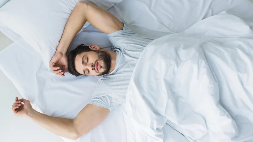 an image of a man sleeping in a bed