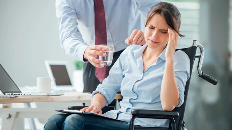 an image of a woman having a migraine headache at work