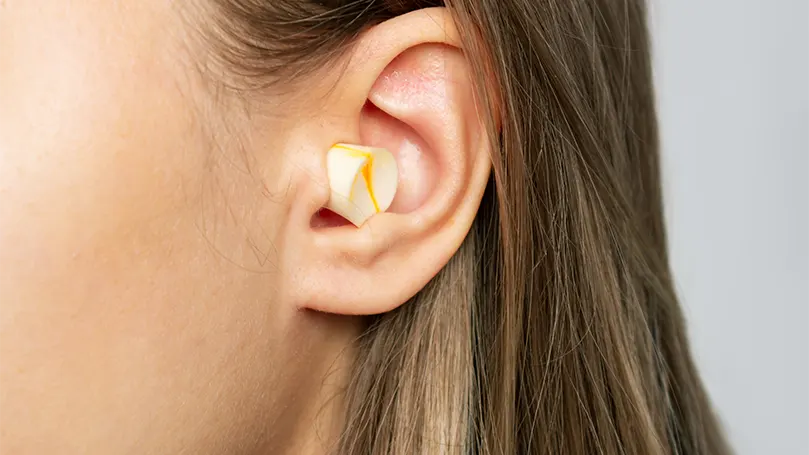 An image of a woman having earplugs.
