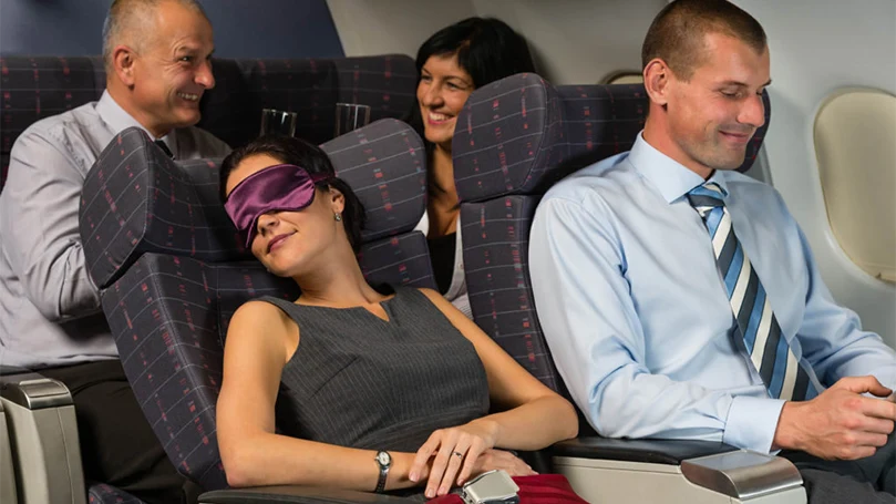 an image of a woman sleeping on a plane with eyemask