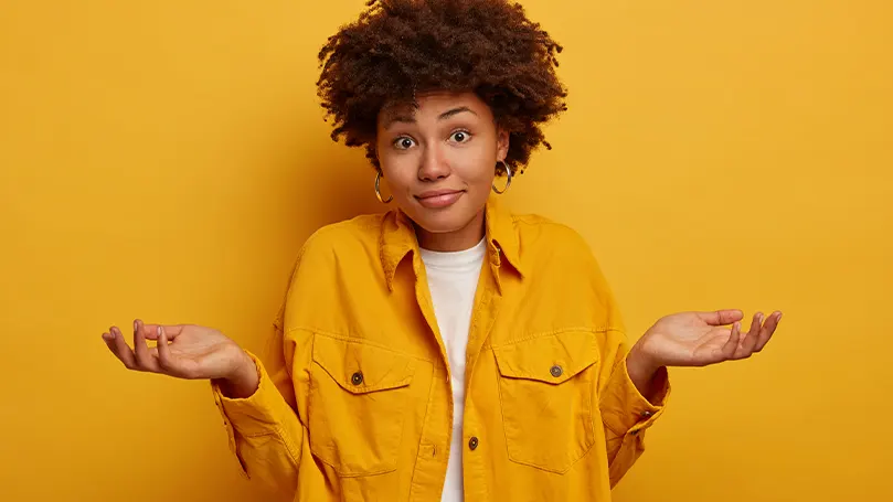 An image of a woman shrugging her shoulders and wondering about something