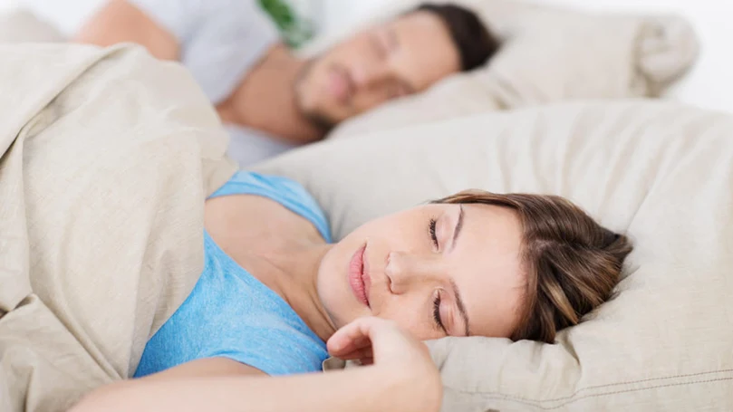 an image of a couple sleeps in a bed