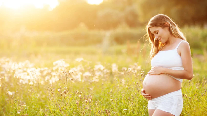 a pregnant woman in a field