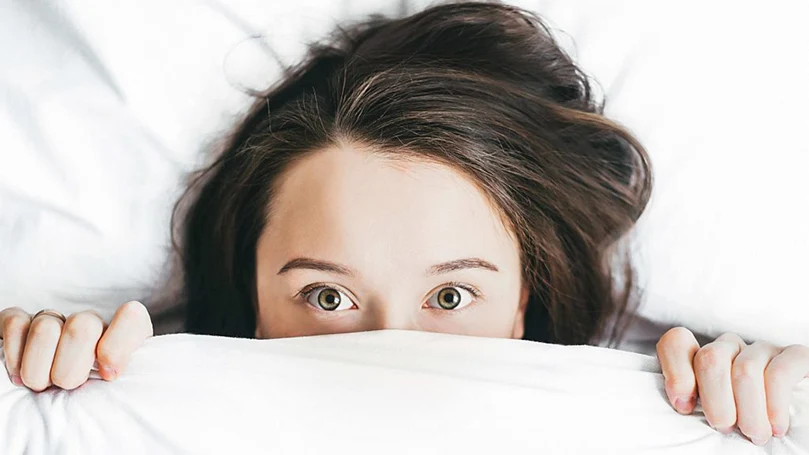an image of a woman covered with a duvet in a bed