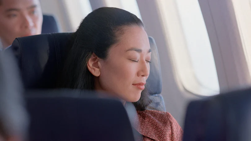 a woman sleeping on a plane