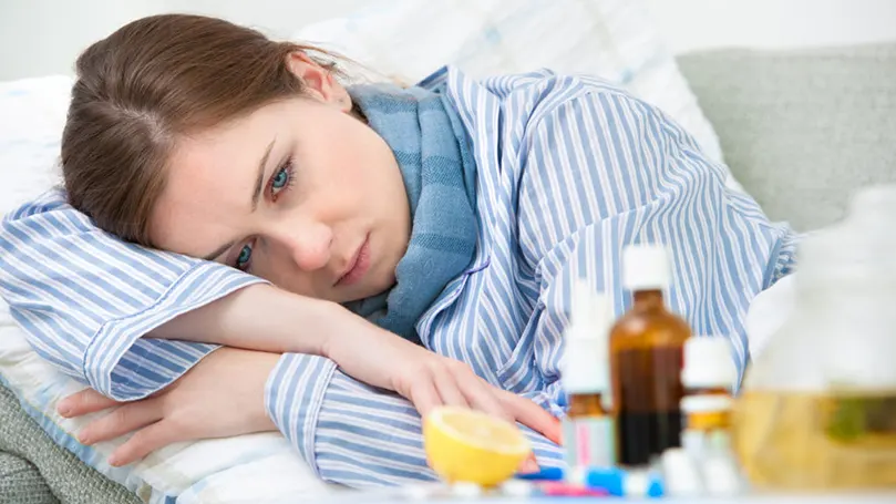 a woman in pajamas next to cold medicine