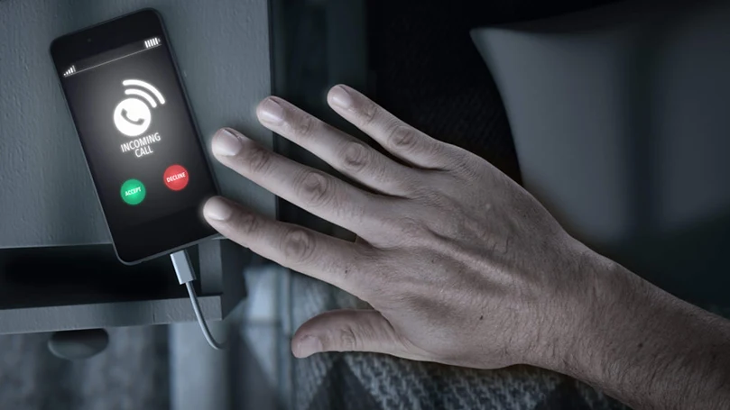 an image of a hand leaving a smartphone on a nightdesk