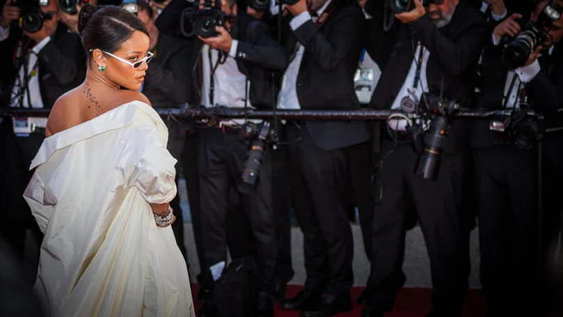 an image of rihanna posing in front of reporters