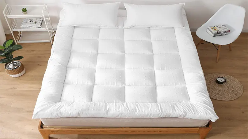 An image of Rejuvopedic new microfiber mattress topper on a mattress in bedroom.