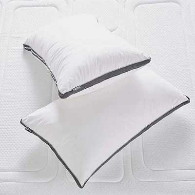 a product image of otty adjustable pillow on a bed