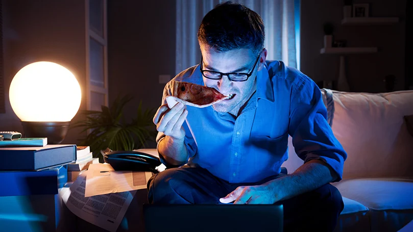 a man working on a laptop late night in the dark