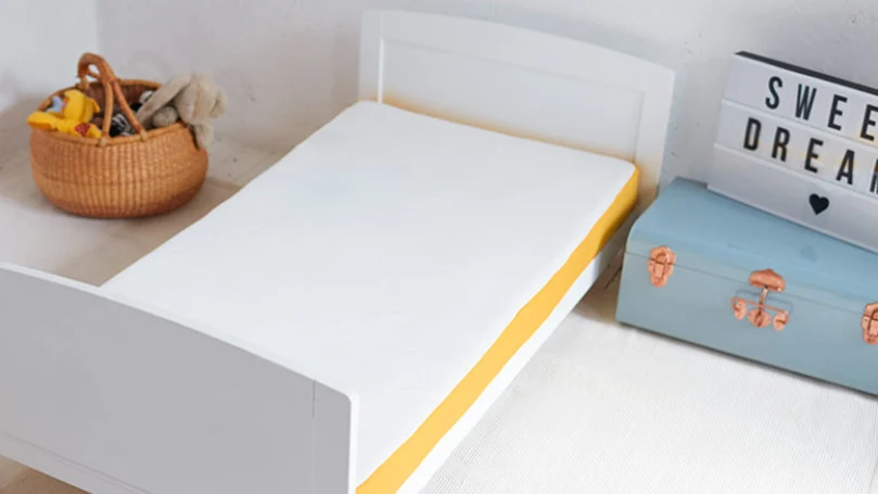 an image of eve cot baby mattress in a kids room
