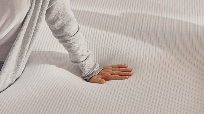 A woman touching a Casper mattress