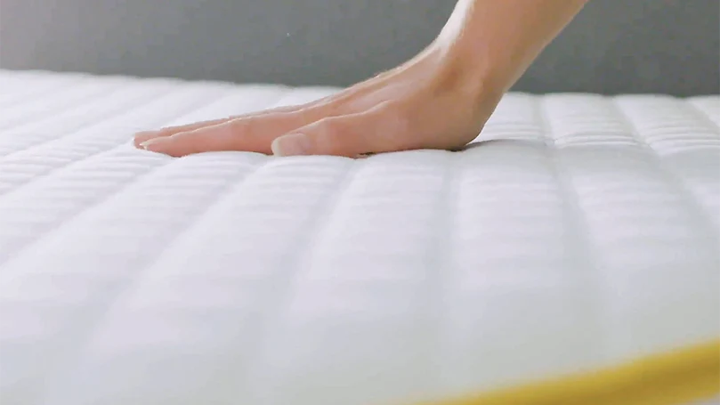an image of a hand pressing Eve Premium mattress