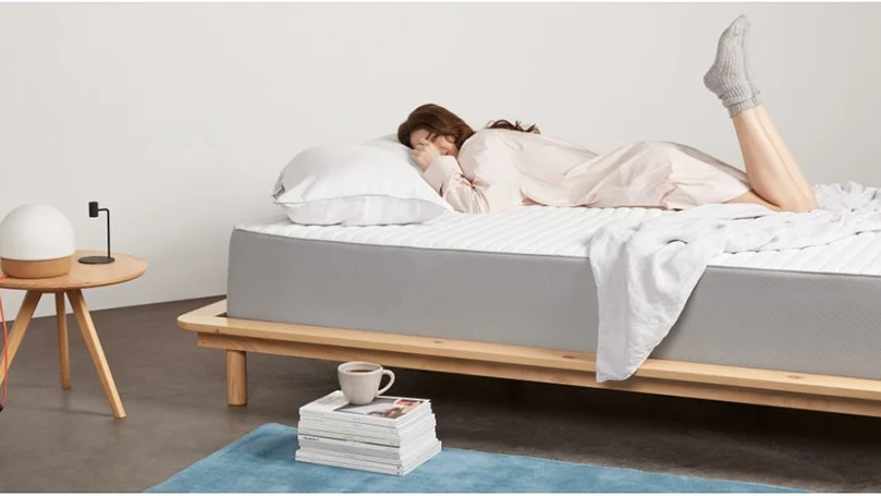 A woman sleeping on a memory foam mattress by Made