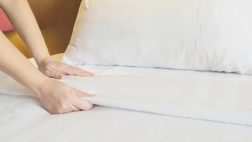 A woman putting on Clean bedding