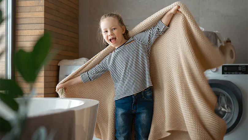 An image of a girl playing with a washed weighted blanket.