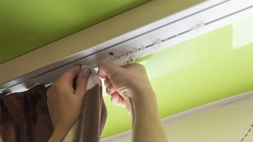 An image of a young man removing blackout curtains.