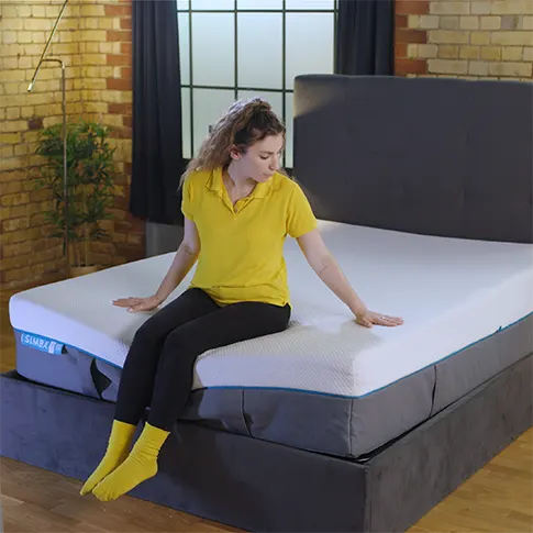 our reviewer sitting on Simba Hybrid Luxe Mattress