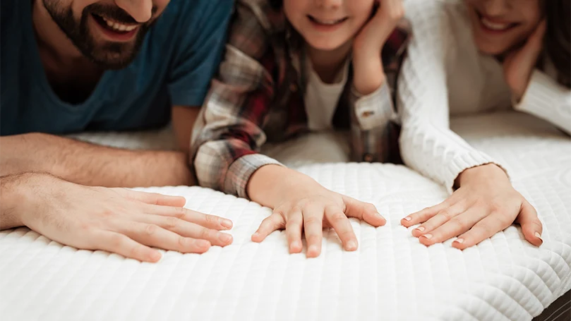 a happy family laying on a mattress