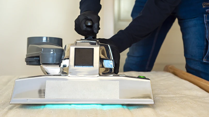 A man deep cleaning and removing dust mites from a mattress topper