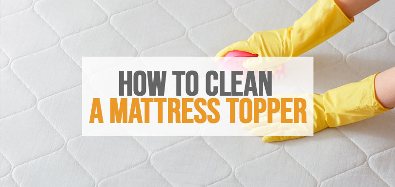 cleaning a mattress topper with a sponge