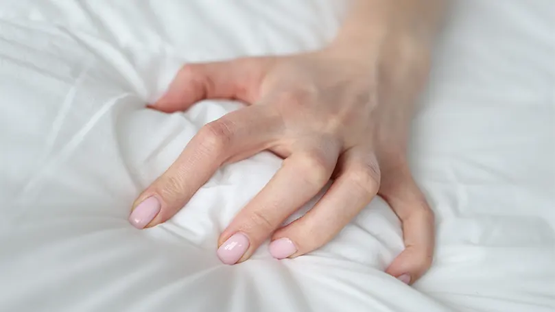 An image if hypoallergenic V pillow squeezed by a hand.