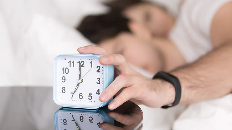 an image of a sleepy man snoozing the alarm