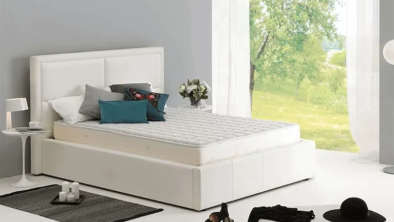 an image of Dormeo Memory Plus mattress on a bed frame in a bedroom