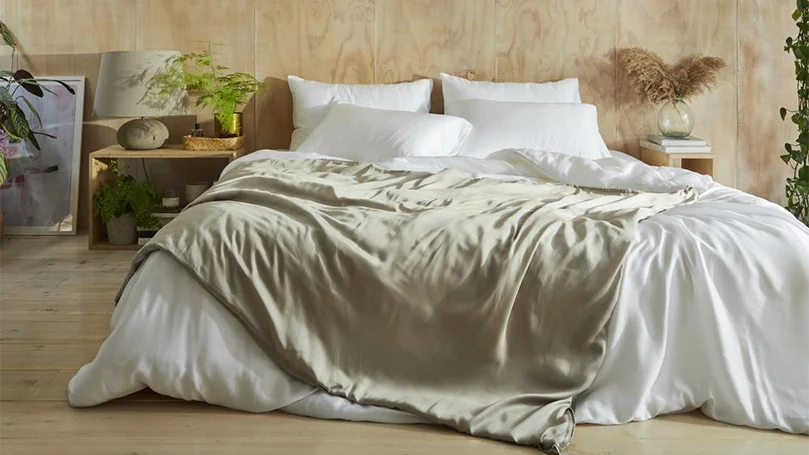 An image of the Mela Chill Eucalyptus Weighted Blanket on a bed in a bedroom