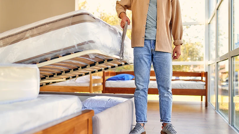 an image of a man opening an ottoman bed frame