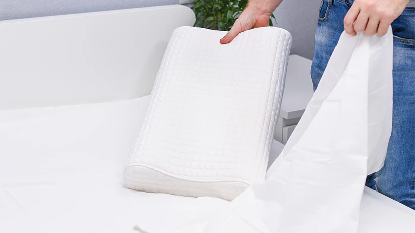 an image of a man putting a cover on a pillow