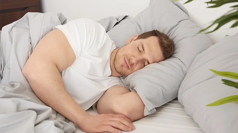 an image of a man sleeping comfortably in his bed
